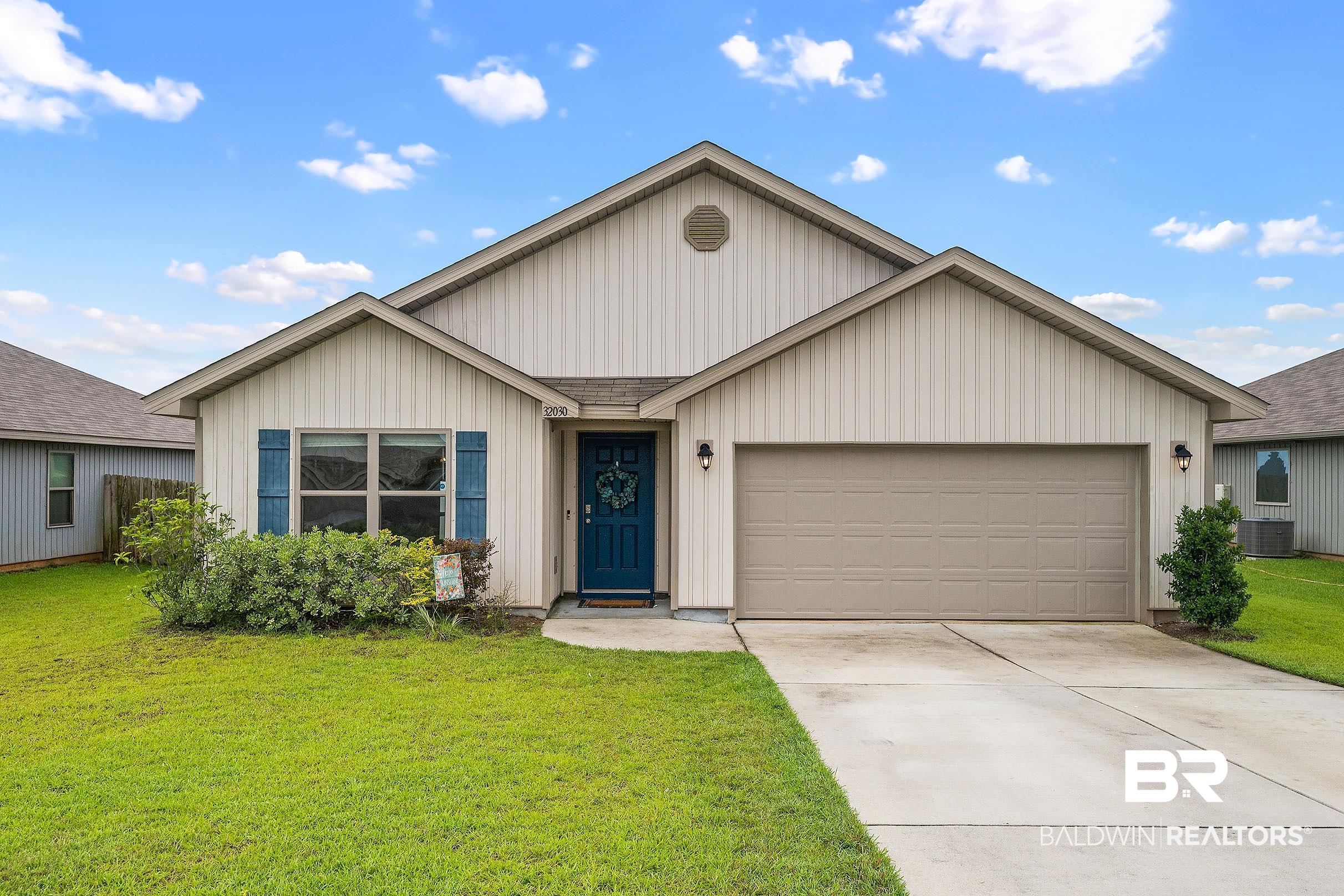 32030 Terranova Loop Lillian, AL 36549 - Photo 2 of 30 Single-story residence featuring light-colored vertical siding, a two-car garage, a blue entry door, and dark blue window shutters