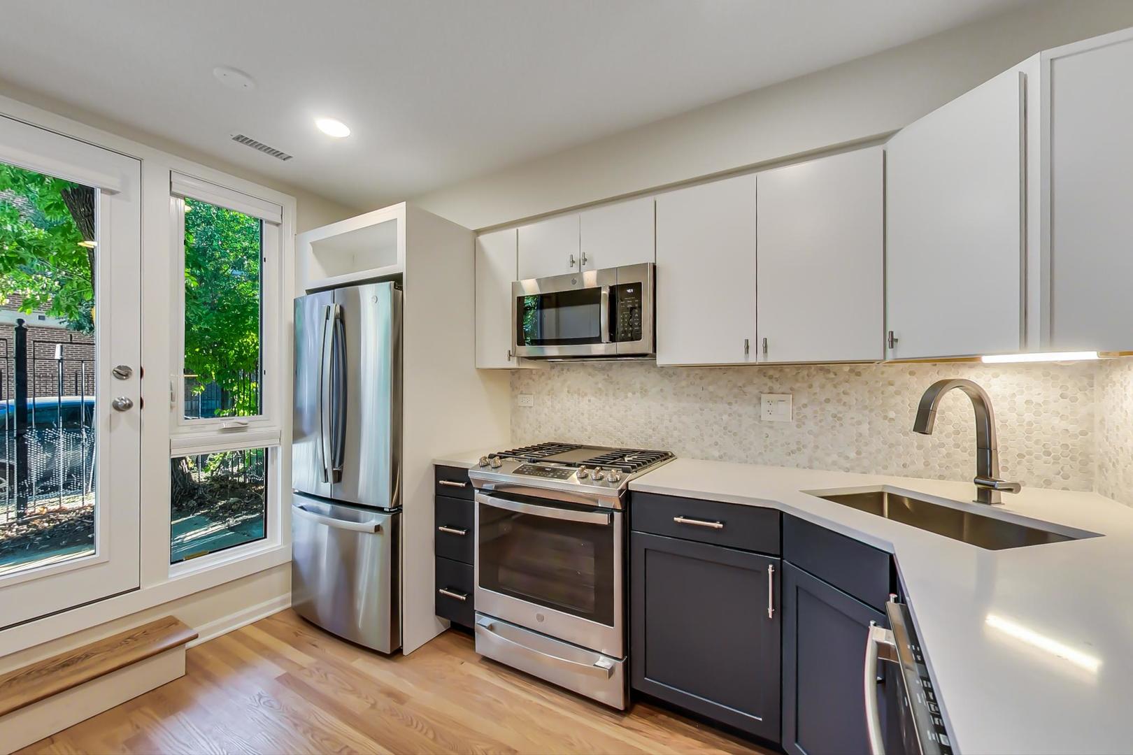 20 West 15th Street, Unit B Chicago, IL 60605 - Photo 3 of 21 a kitchen with stainless steel appliances a stove a sink and a microwave