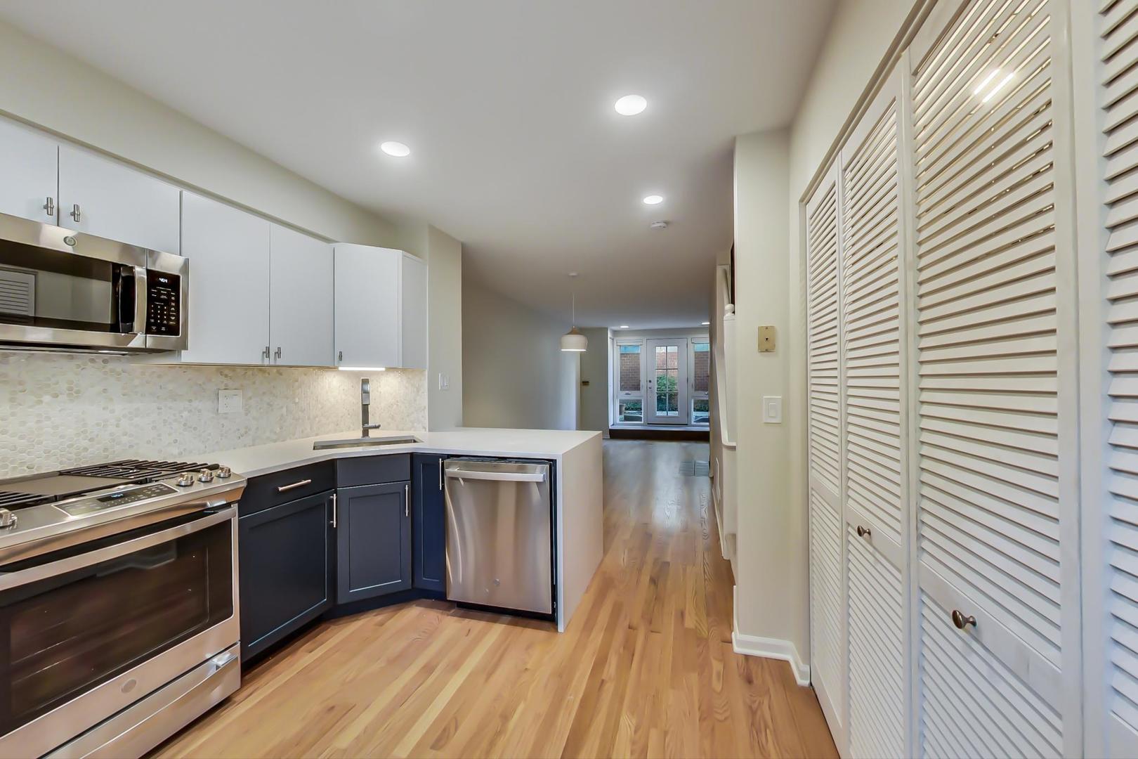 20 West 15th Street, Unit B Chicago, IL 60605 - Photo 4 of 21 a kitchen with stainless steel appliances a sink dishwasher a stove top oven a refrigerator with wooden floor and cabinets