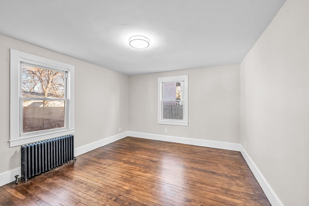 97 Parallel Street Springfield, MA 01104 - Photo 14 of 42 an empty room with wooden floor and windows