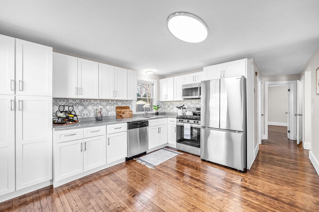 97 Parallel Street Springfield, MA 01104 - Photo 9 of 42 a kitchen with white cabinets and stainless steel appliances