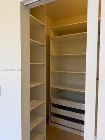 a view of walk in closet with empty racks