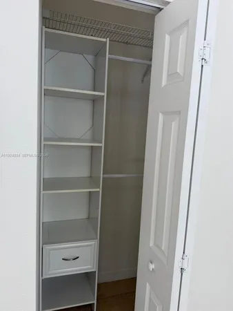 a view of walk in closet with empty racks