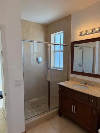 a bathroom with a shower sink and mirror