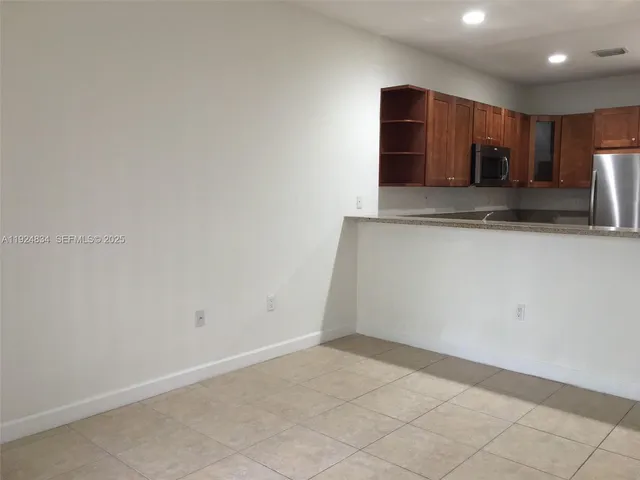 a view of kitchen with stainless steel appliances cabinets and empty counter top space