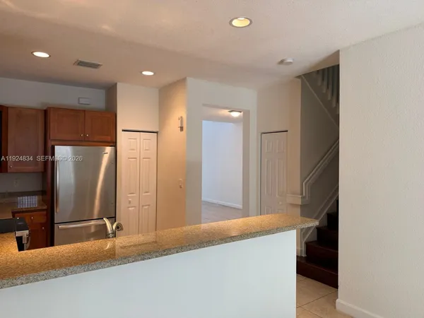 a kitchen with stainless steel appliances granite countertop a refrigerator and a sink