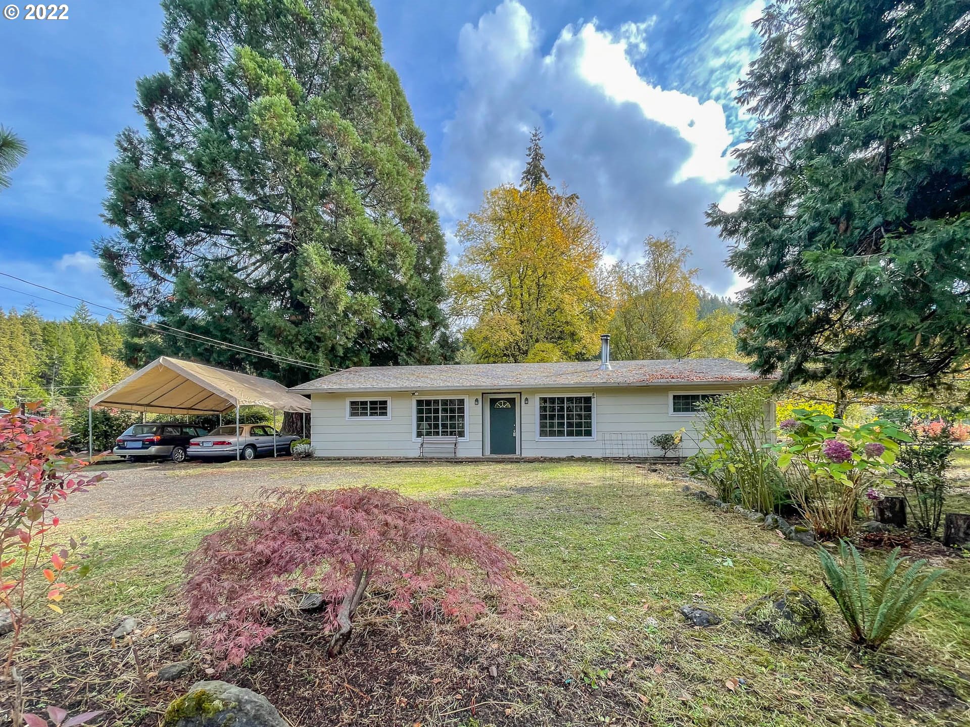 695 Lone Rock Road Glide, OR 97443 - Photo 1 of 48 a view of a house with garden and sitting area