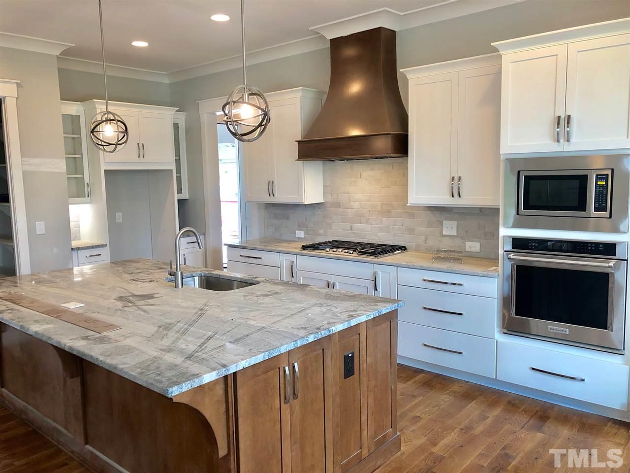 112 Roseroot Court Holly Springs, NC 27540 - Photo 3 of 30 a kitchen with granite countertop a stove and a sink