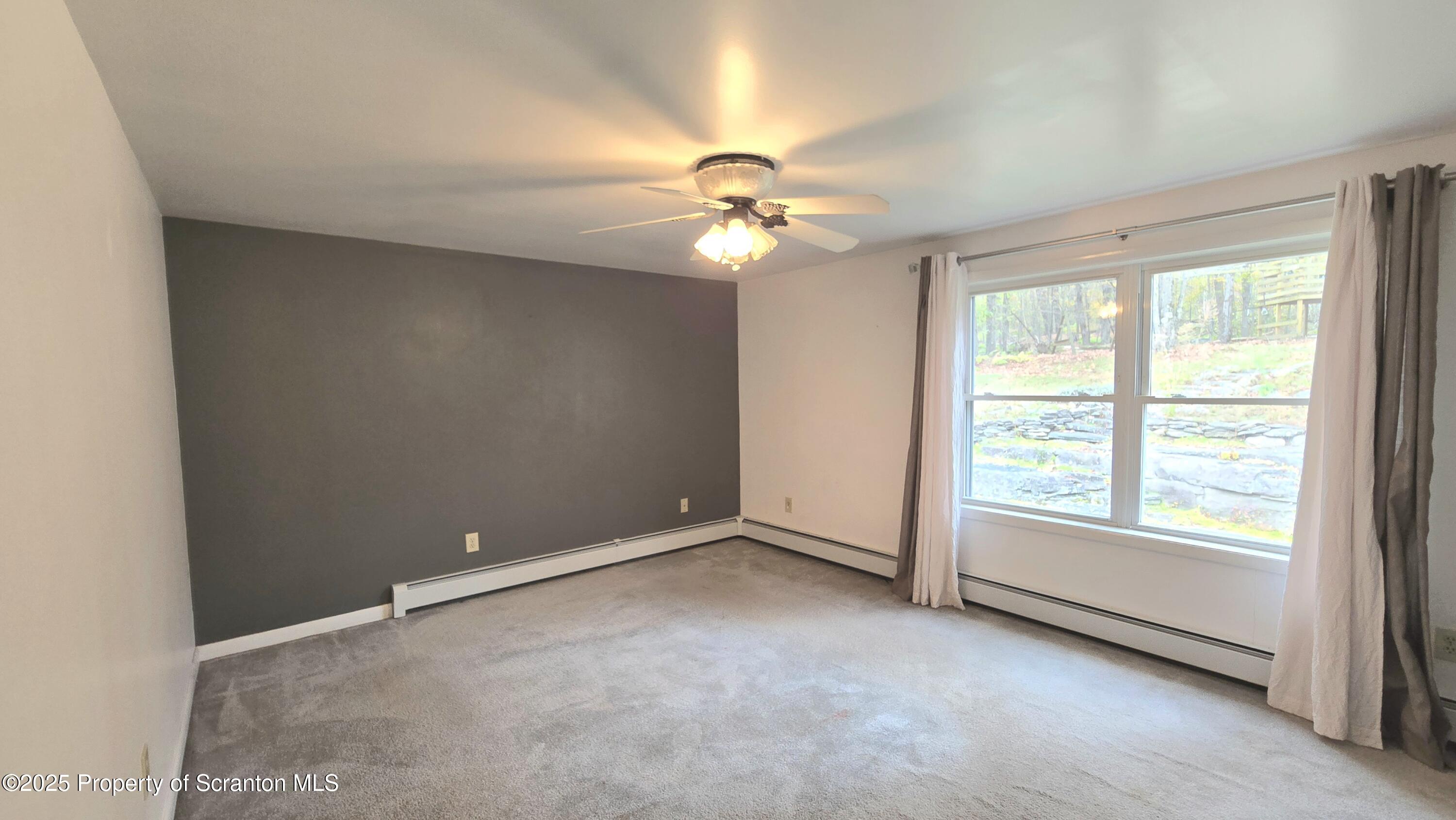 2311 Motichka Road Moscow, PA 18444 - Photo 17 of 89 an empty room with windows and fan chandelier fan