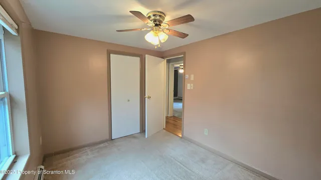 a view of water heater room with a door and wooden floor