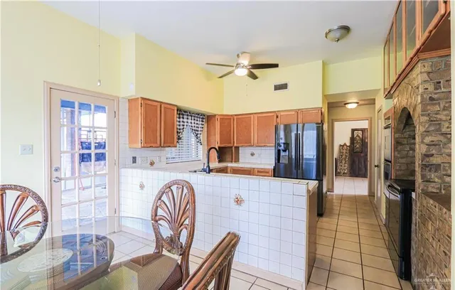 a large kitchen with stainless steel appliances granite countertop a table chairs in it and a window