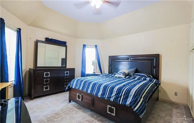 a bedroom with a bed and a flat tv screen on dresser