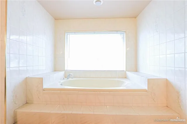 a bathroom with a bathtub and a window