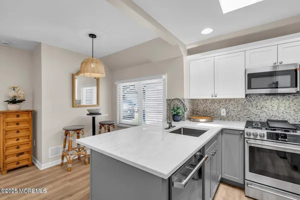 a kitchen with a stove a sink a window and dining table