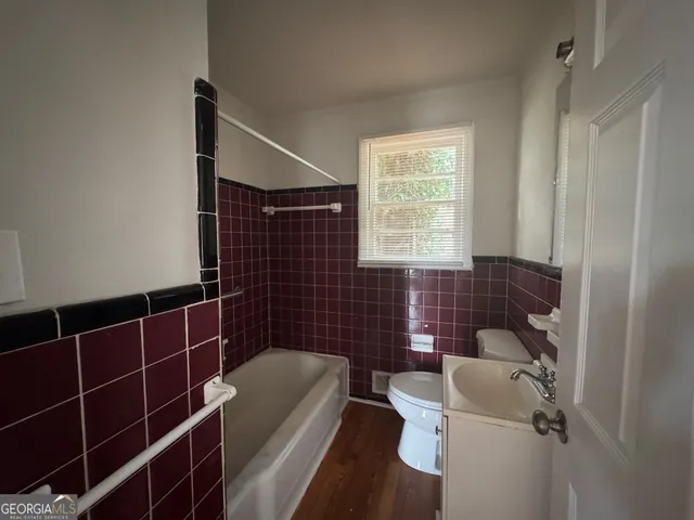 a bathroom with a toilet a bath tub and a window