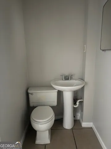 a bathroom with a sink toilet and a mirror