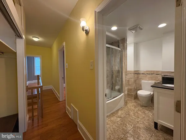 a bathroom with a granite countertop sink a toilet and shower