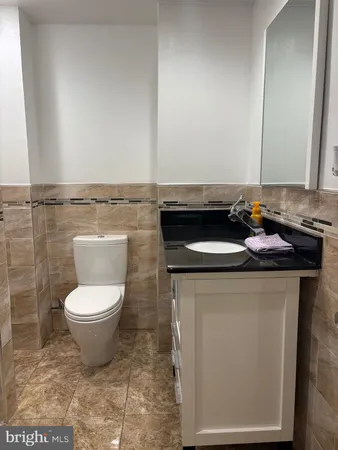 a bathroom with a granite countertop toilet and a sink