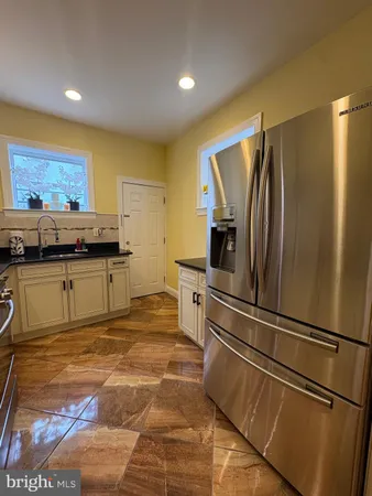 a kitchen with stainless steel appliances granite countertop a refrigerator and a sink