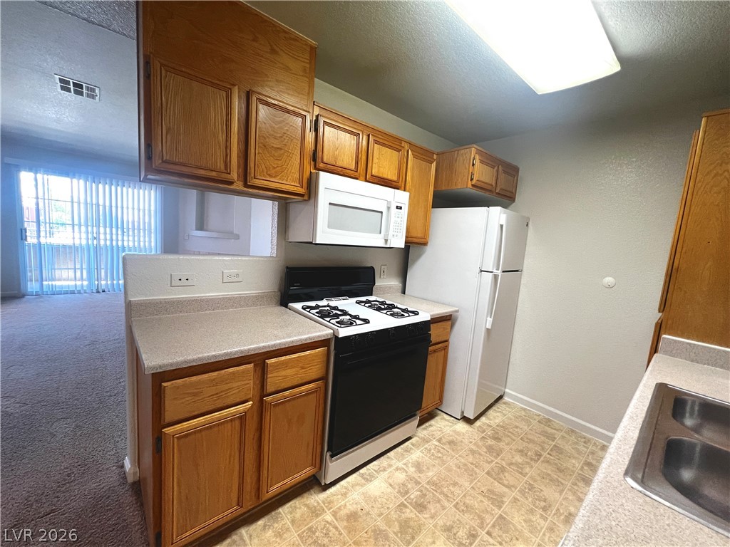 4730 East Craig Road, Unit 2104 Las Vegas, NV 89115 - Photo 6 of 20 Functional kitchen with ample cabinetry and essential appliances.