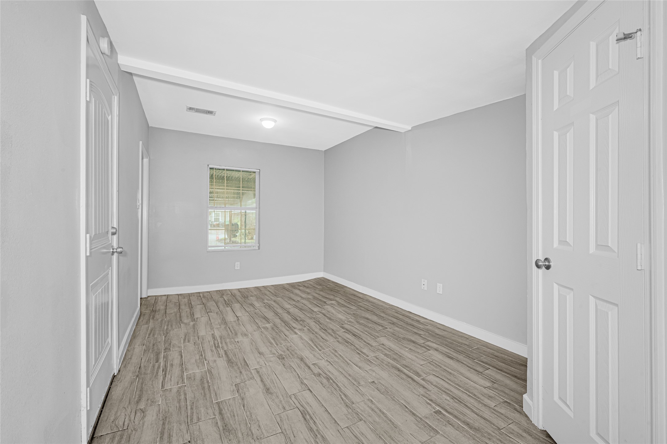 5009 Bataan Road Houston, TX 77033 - Photo 17 of 24 a view of an empty room with wooden floor and a window