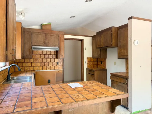 a kitchen with a refrigerator and a stove top oven