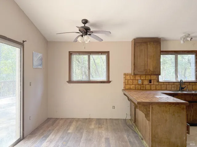 a room with a sink cabinets wooden floor and a window