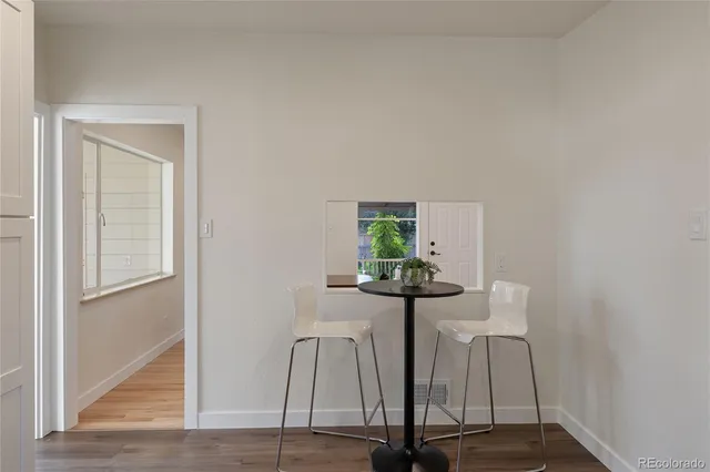 a view of a room with wooden floor and a table
