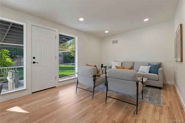 a living room with furniture and a wooden floor