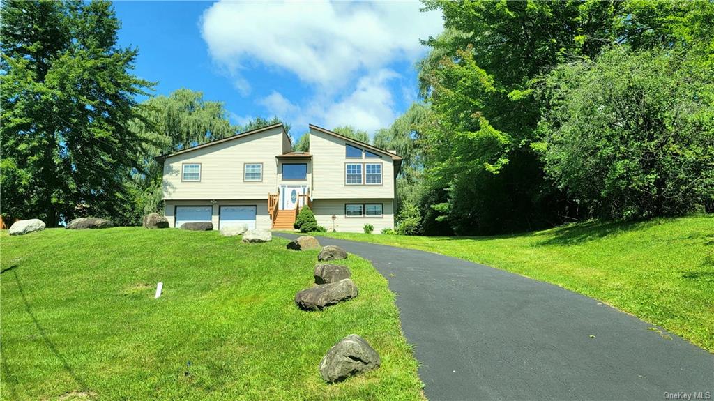 a front view of a house with a yard and trees
