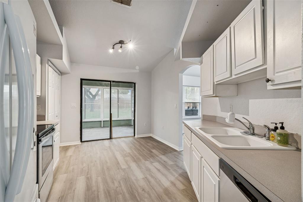 2255 Ancho Avenue Spring Hill, FL 34608 - Photo 12 of 24 a kitchen with granite countertop a sink and dishwasher refrigerator a oven with wooden floors