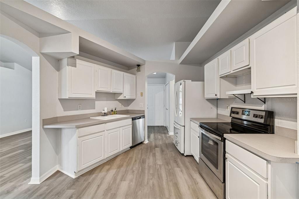 2255 Ancho Avenue Spring Hill, FL 34608 - Photo 13 of 24 a kitchen with a sink stainless steel appliances and white cabinets