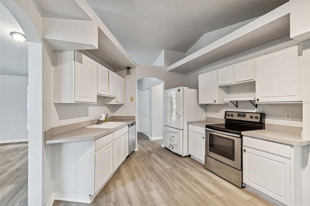 2255 Ancho Avenue Spring Hill, FL 34608 - Photo 14 of 24 a kitchen with white cabinets and appliances
