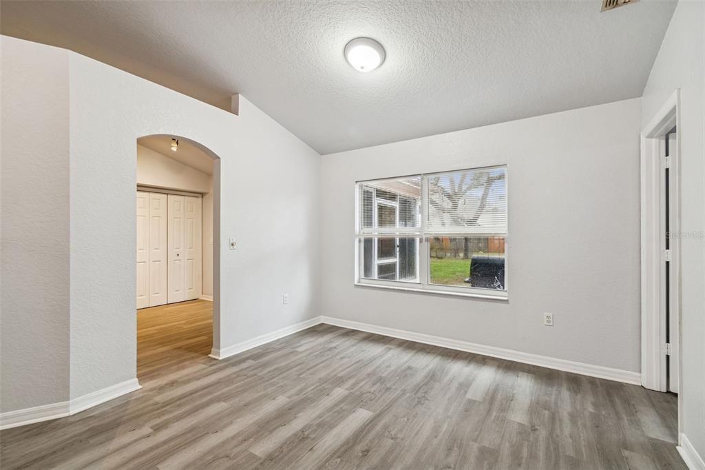 2255 Ancho Avenue Spring Hill, FL 34608 - Photo 7 of 24 an empty room with wooden floor and windows