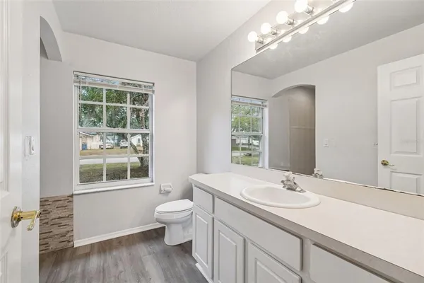 a bathroom with a sink a large mirror and a window