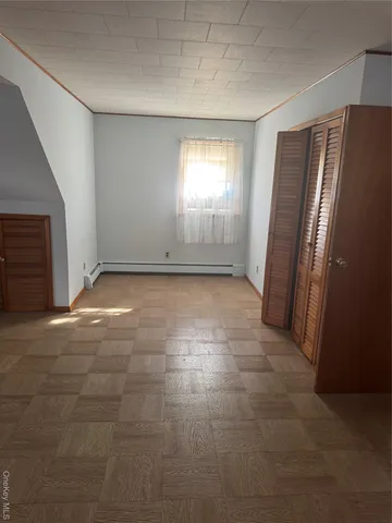 an empty room with windows and closet