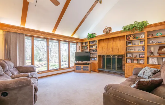 a living room with furniture a flat screen tv and a floor to ceiling window