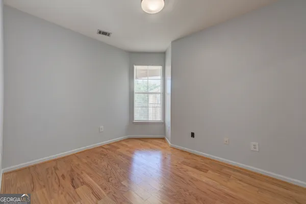 an empty room with cabinet and windows