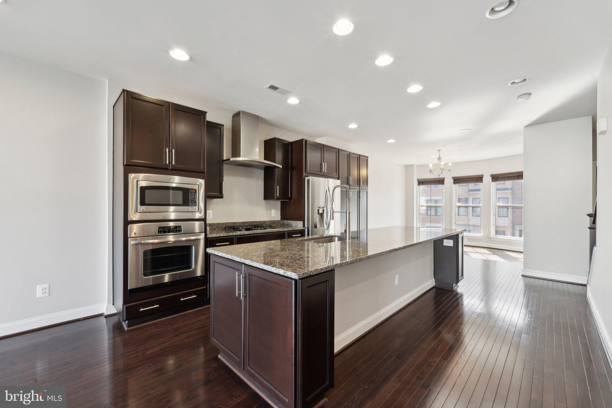 20398 Codman Drive Ashburn, VA 20147 - Photo 11 of 39 a kitchen with stainless steel appliances kitchen island granite countertop a stove and a refrigerator