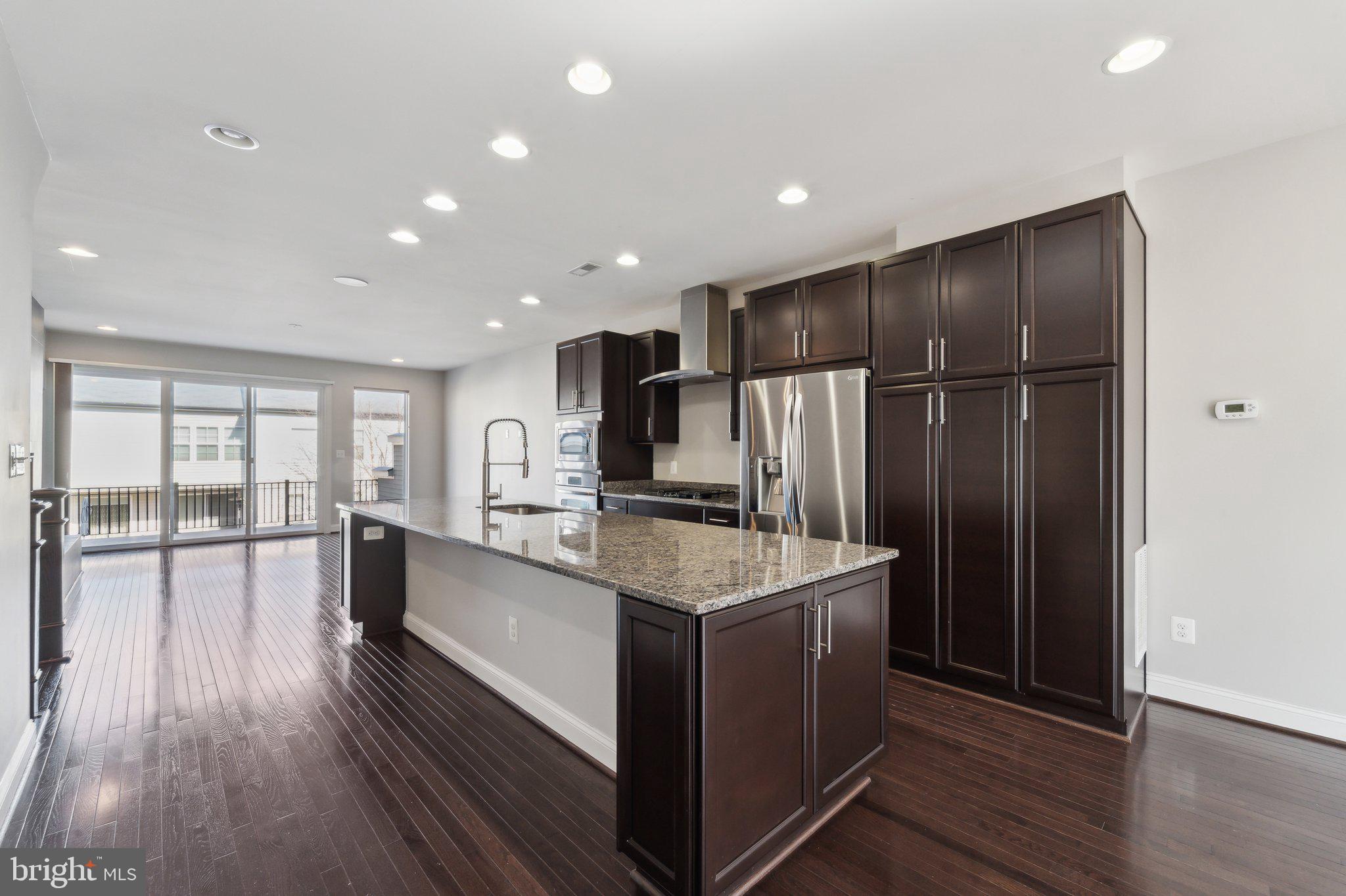 20398 Codman Drive Ashburn, VA 20147 - Photo 16 of 39 a large kitchen with kitchen island a large counter top space a sink and stainless steel appliances