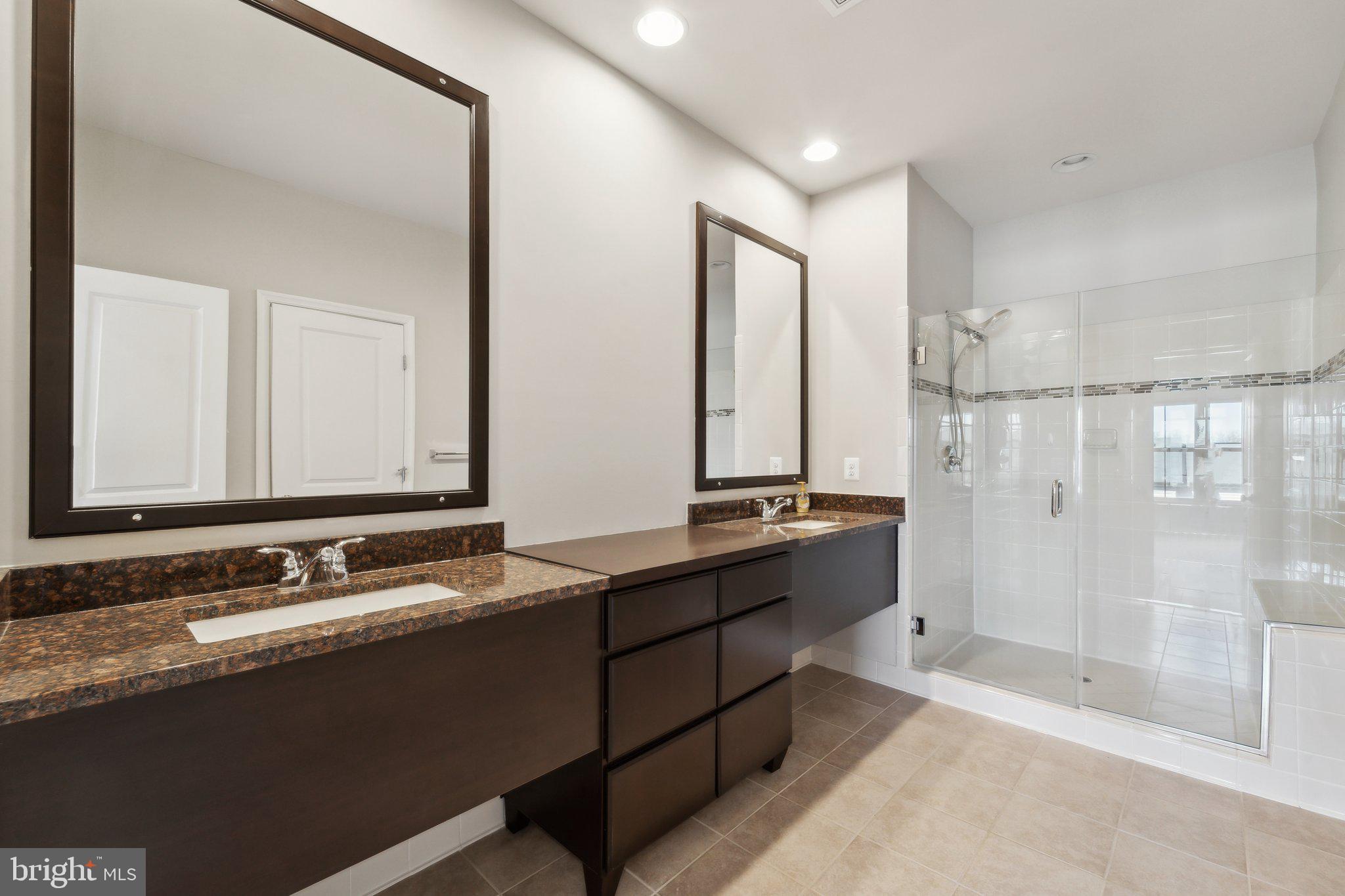 20398 Codman Drive Ashburn, VA 20147 - Photo 27 of 39 a bathroom with a double vanity sink and mirror with shower