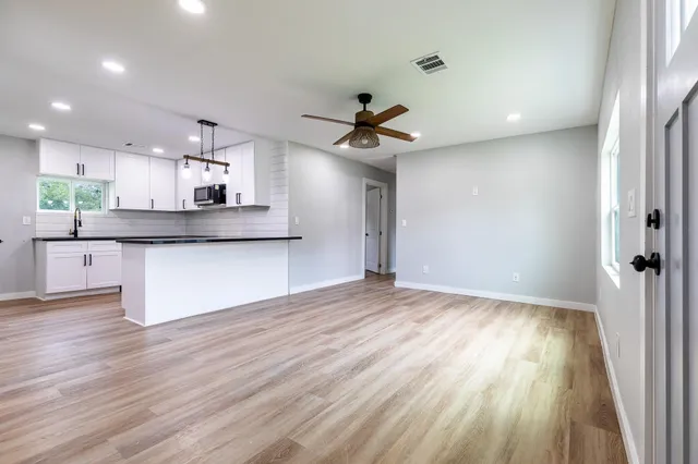 a view of a kitchen with a sink and wooden floor