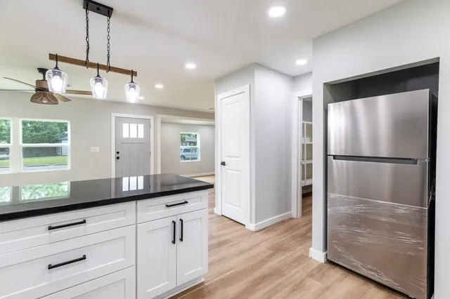 a kitchen with kitchen island white cabinets and stainless steel appliances