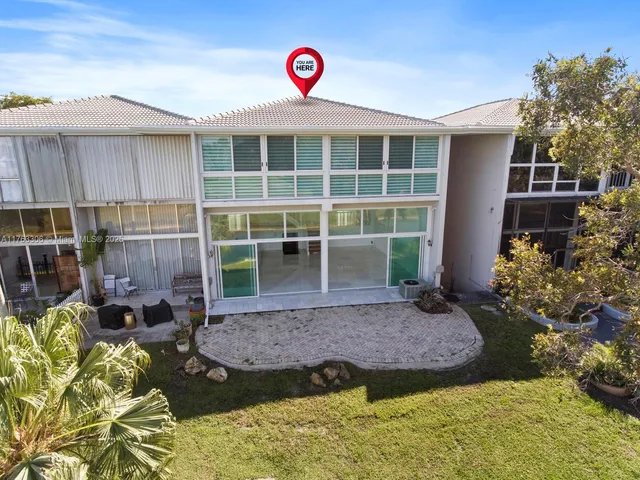 an aerial view of a house with swimming pool and patio