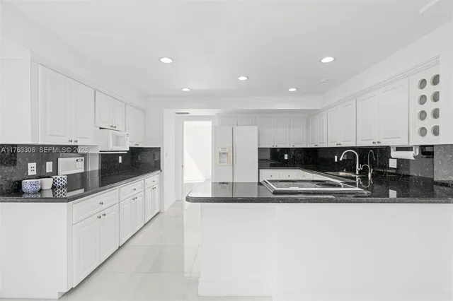 a kitchen with white cabinets and appliances
