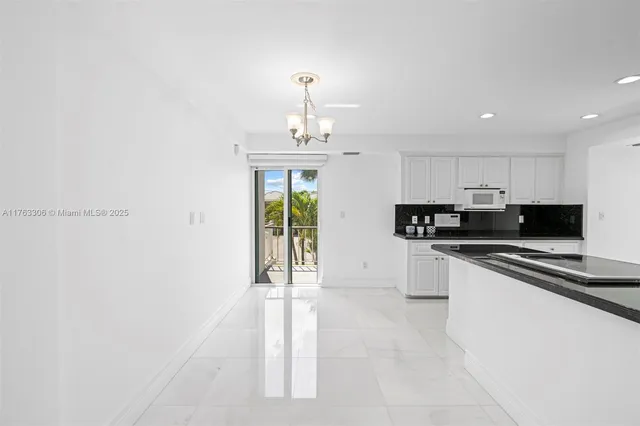 a kitchen with granite countertop white cabinets and a sink