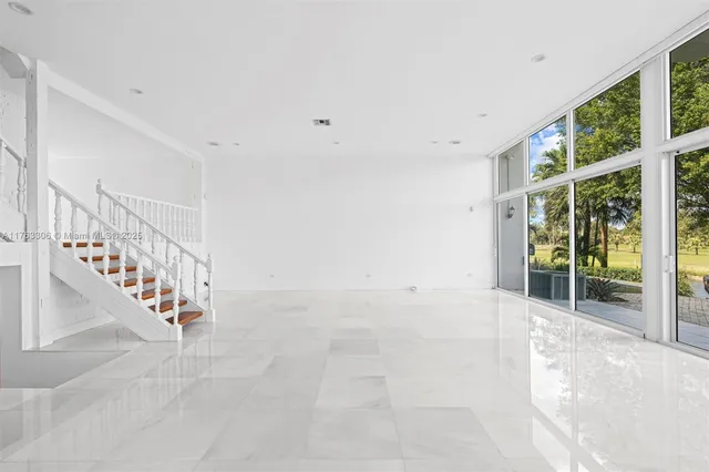 a large white kitchen with stainless steel appliances granite countertop a stove and a refrigerator