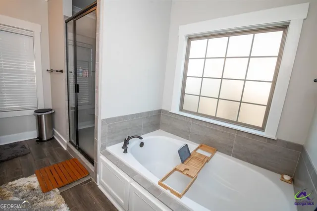 a bathroom with a tub sink and glass door