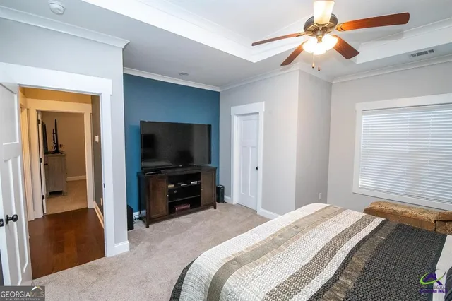 a bedroom with a bed and a flat tv screen on dresser