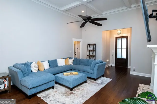 a living room with furniture and a wooden floor